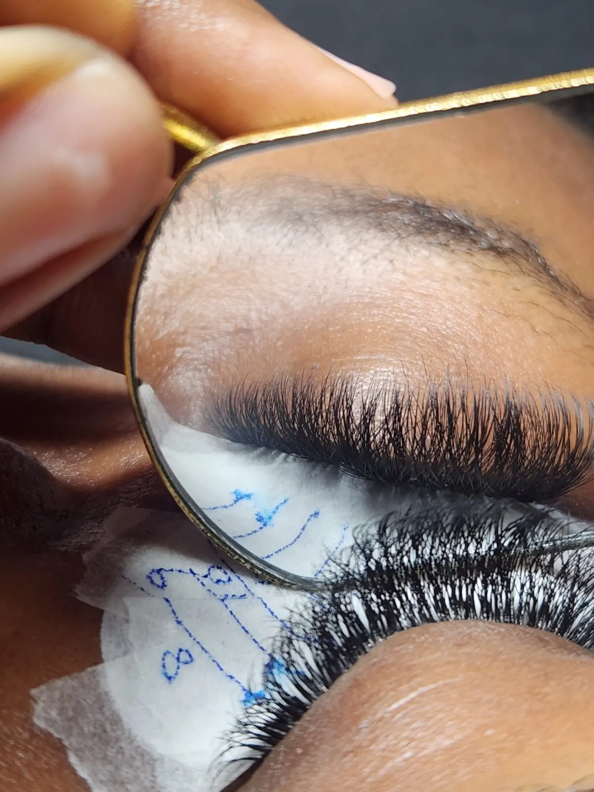 Classic lash extensions shown in a gold hand mirror at Beauty by Haks