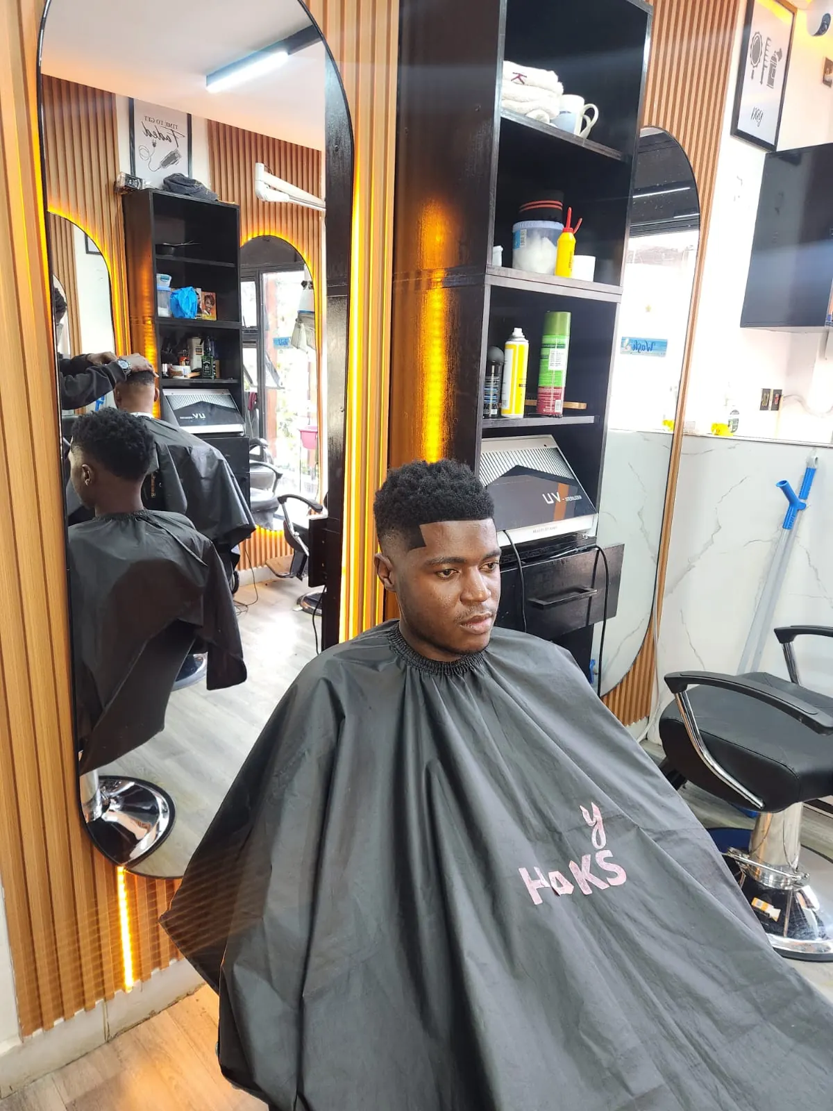 Men's high fade haircut in a Beauty by Haks barber cape