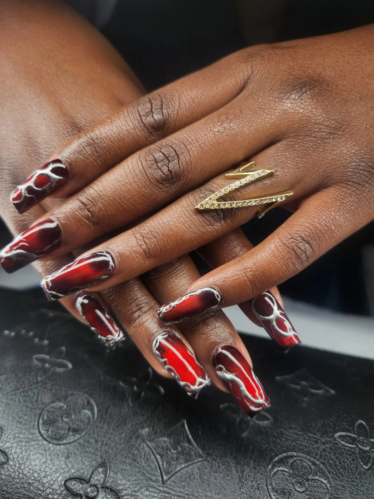 Red chrome coffin nails with a gold ring